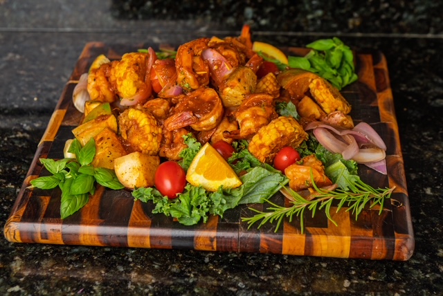 Glazed chicken with oranges and herbs on a wooden board